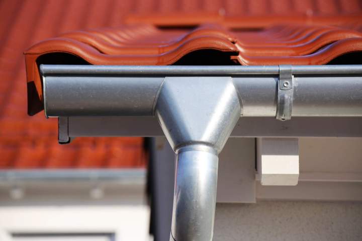Gros plan sur des éléments de zinguerie gouttières, chéneaux en zinc sur une toiture, finitions parfaites, intégration esthétique, protection contre les intempéries.